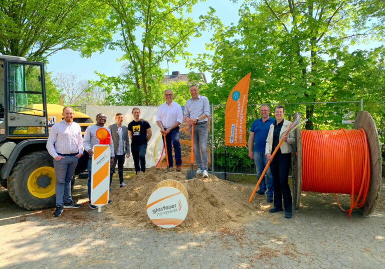 Bürgermeister Dirk Tolkemitt (auf dem Hügel rechts) freut sich mit Carsten Höfinghoff (auf dem Hügel links) sowie Mitarbeitenden von Verwaltung und ausführender Fachfirmen über den Ausbaustart in Schötmar und Ehrsen. Foto: Stadt Bad Salzuflen