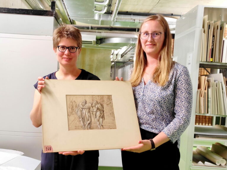 Dr. Christine Rühling (links, Lippische Landesbibliothek) und Projektmitarbeiterin Isabelle Christiani, mit einer der fraglichen Zeichungen: Mariette, 3 alte Männer, Tuschezeichnung, weiß gehöht. Fotoquelle: Lippische Landesbibliothek