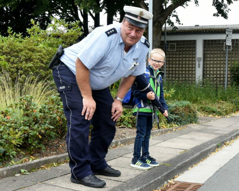 Polizist erklärt Schulkind richtiges Verhalten auf dem Schulweg. Fotoquelle: Polizei NRW