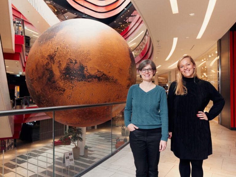 „Maria Munzert (l.) und Gesa Fischer von der Wissenswerkstadt Bielefeld haben den roten Riesen in Kooperation mit "Science2public" aus Halle/Saale nach Bielefeld geholt.“ Foto: Patrick Pollmeier