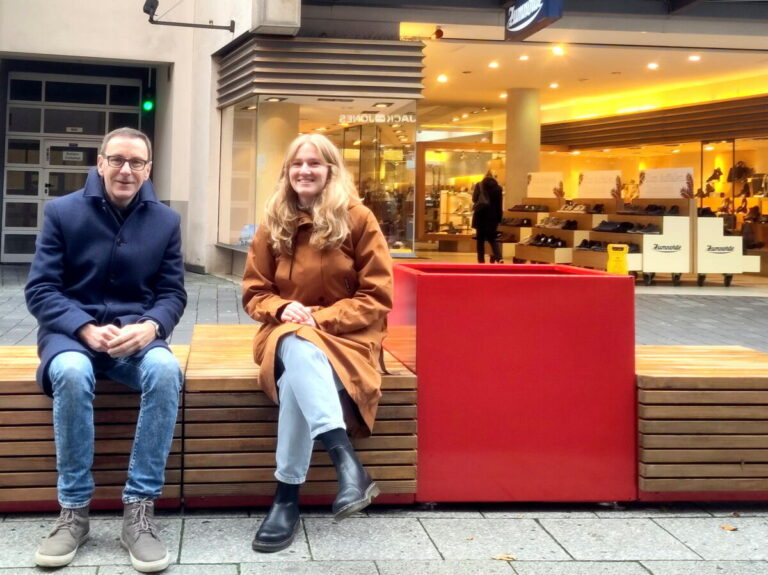 Probieren die neuen Sitzmöbel in der Bielefelder Innenstadt aus: Olaf Lewald, Leiter des Amts für Verkehr, und Johanne Struck, Teil des City.Teams und des Bauamts. Foto: Stadt Bielefeld