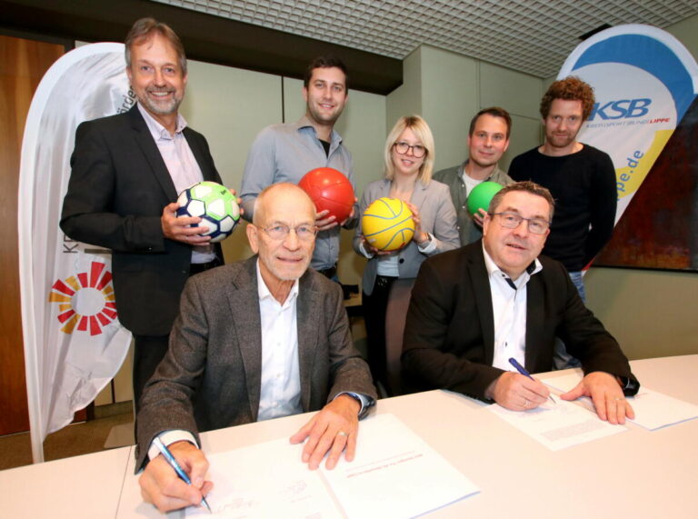 (v.l.) Markus Rempe (Fachdienstleistung für Bildung, Kreis Lippe), Christopher Tegethoff (Geschäftsführung, KSB), Sina Harst (Sportförderung, Kreis Lippe), Christian Jungk (Sportförderung, Kreis Lippe) und Max Beuys (Geschäftsführung, KSB). Im Vordergrund unterzeichnen Friedhelm Böger und Dr. Axel Lehmann den Pakt. Foto: Kreis Lippe