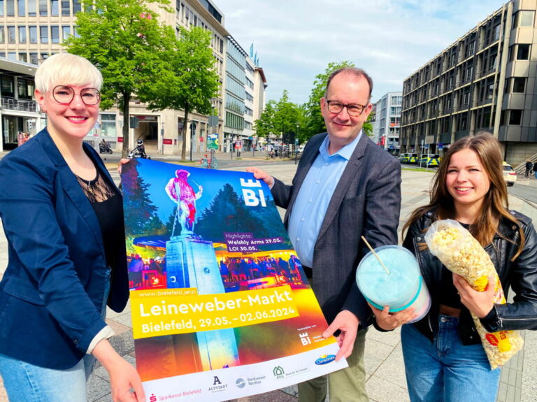 Vom Bielefeld Marketing zeigen (v.l.) Katharina Schilberg, Martin Knabenreich und Karoline Jockheck am Niederwall den Standort für den brandneuen „Nordic Tower“, womit Fans des Nervenkitzels durch die Lüfte fliegen können. Kein Leuchtturm in Europa soll höher als das Kettenkarussell mit 90 Metern Höhe sein. Foto: Bielefeld Marketing GmbH