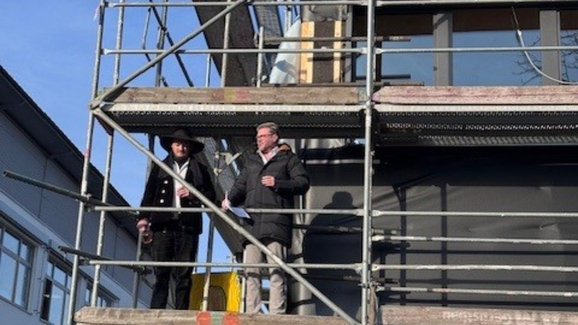 Kurz vor dem Richtspruch: Zimmermann Henrik Sonnenburger und Bürgermeister Peter Heepmann auf dem Gerüst des voranschreitenden Erweiterungsbaus der Grundschule Helpup. Foto: Stadt Oerlinghausen