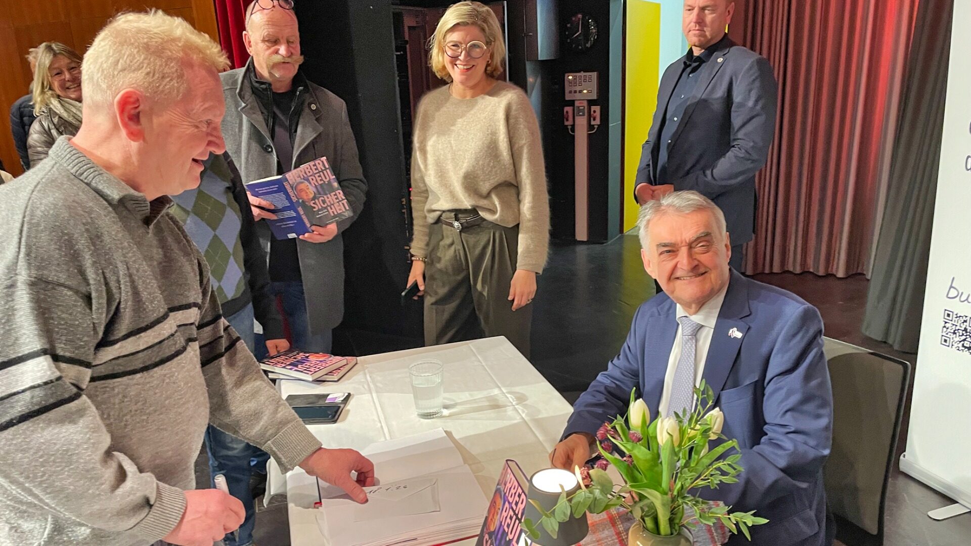Der Innenminister des Landes NRW, Herbert Reul, signiert mit großer Ausdauer sein erstes Buch. Im Hintergrund Cerris Wehrmann-Ristau, Inhaberin der Buchhandlung Blume in Oerlinghausen, die den Abend veranstaltete.  Foto: Reiner Toppmöller