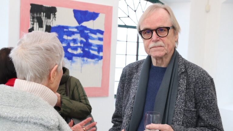 Wolfgang Troschke (hier im Gespräch mit einer Besucherin) gilt als ein virtuoser Meister sämtlicher grafischer Drucktechniken, die er miteinander und mit seiner Malerei kombiniert.  Foto: kd