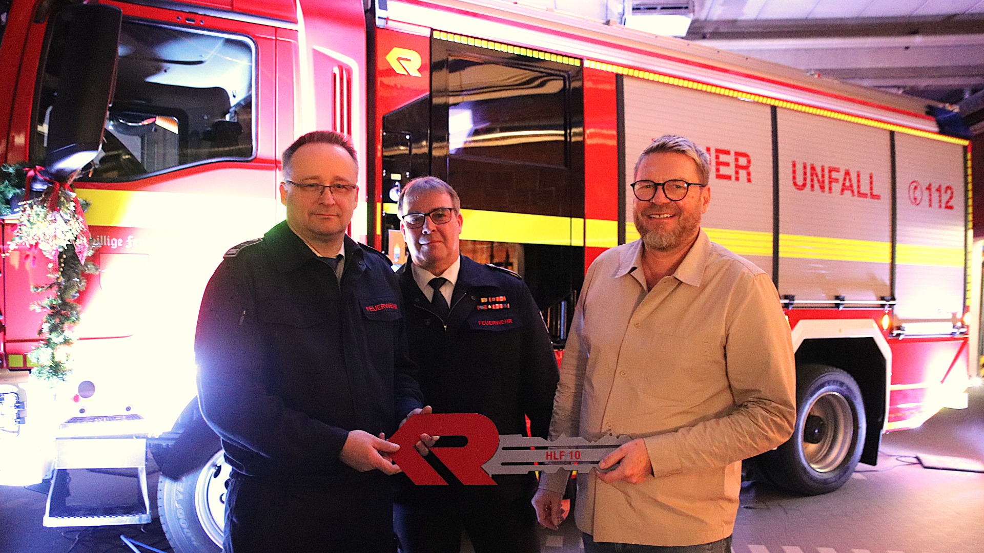 Löschzugführer Udo Sieveke (links) nimmt den symbolischen Schlüssel für das neue Fahrzeug von Bürgermeister Peter Heepmann entgegen. Thomas Kronshage, der Leiter der Oerlinghauser Feuerwehr, freut sich über die Ersatzbeschaffung. Foto: kd