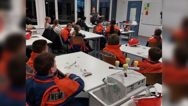 In kleinen Experimenten beschäftigten sich die Mädchen und Jungen der Jugendfeuerwehr mit den Grundlagen der Verbrennung. Kirsten Hanekamp und Elsa Rieger sensibilisierten den Feuerwehrnachwuchs für die Risiken bei Bränden und Feuerwehreinsätzen. Fotos: Christian Landerbarthold