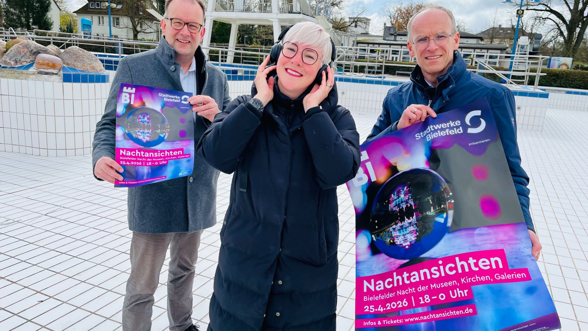 Das Schwimmbecken im Wiesenbad wird zur Tanzfläche: (v. l.) Martin Knabenreich und Katharina Schilberg (beide Bielefeld Marketing) freuen sich mit Martin Uekmann (Stadtwerke Bielefeld) auf die Nachtansichten 2026.Foto: Bielefeld Marketing GmbH