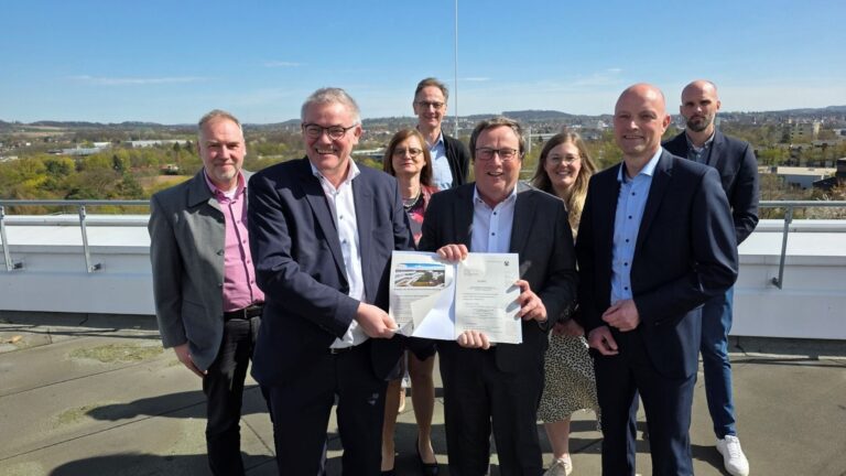 Umweltminister Oliver Krischer (Mitte) und Jens Kronsbein, Leiter der Abteilung Regionale Entwicklung bei der BezReg (rechts), überreichen Rainer Grabbe (links) und dem Projektteam beim Kreis Lippe den Förderbescheid für die Umsetzung der klimaangepassten Außenanlagen am Kreishaus. © Kreis Lippe