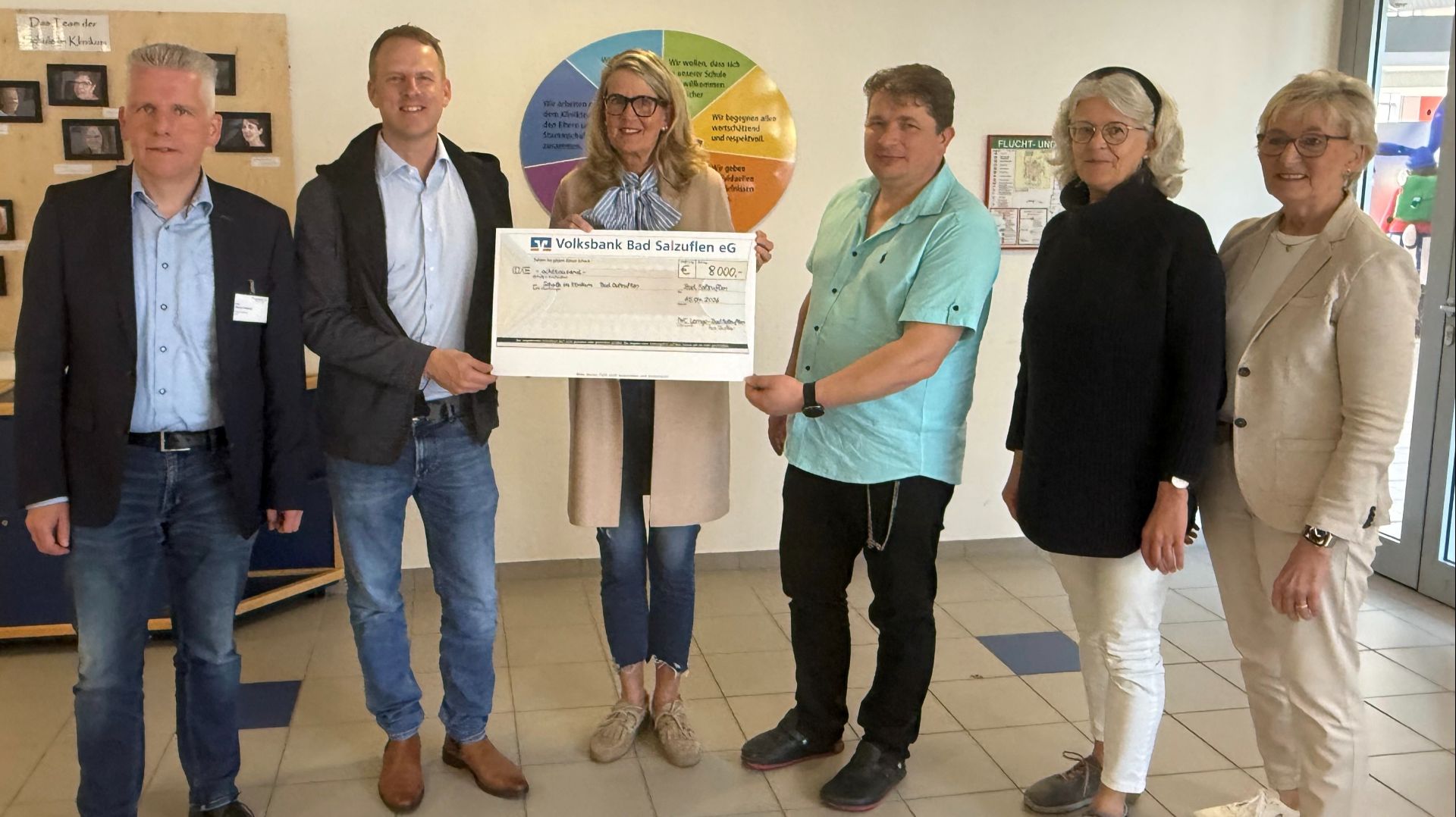 Drei Männer und drei Frauen überreichen einen Spendenscheck der Volksbank Bad Salzuflen über 8000 Euro