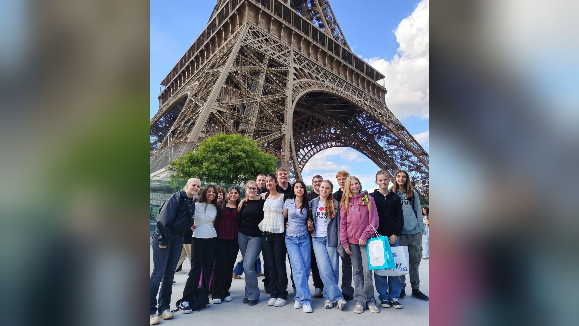 Schüler der Gesamtschule Aspe stehen lächelnd vor dem Eiffelturm in Paris während ihres Erasmus+ Austauschs