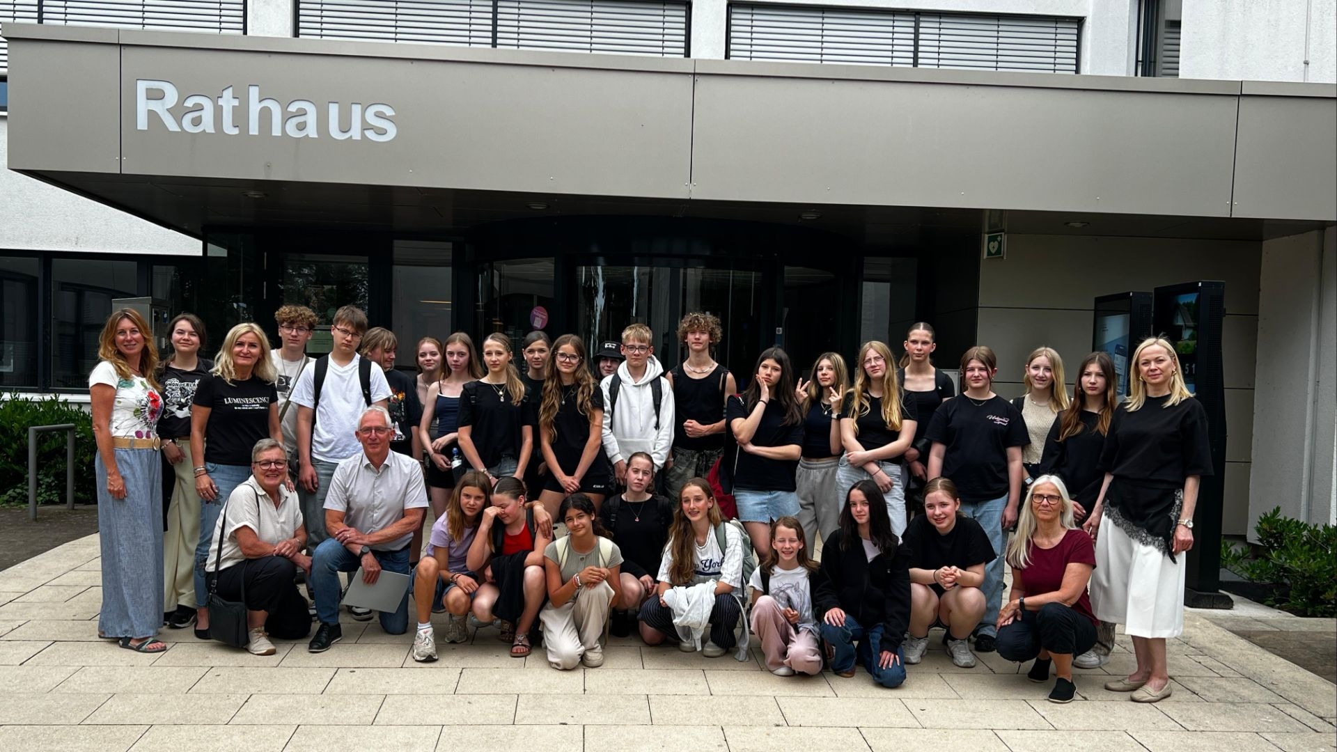 Große Gruppe polnischer Schüler und Erwachsener macht ein Gruppenfoto vor einem Gebäude mit der Beschriftung Rathaus