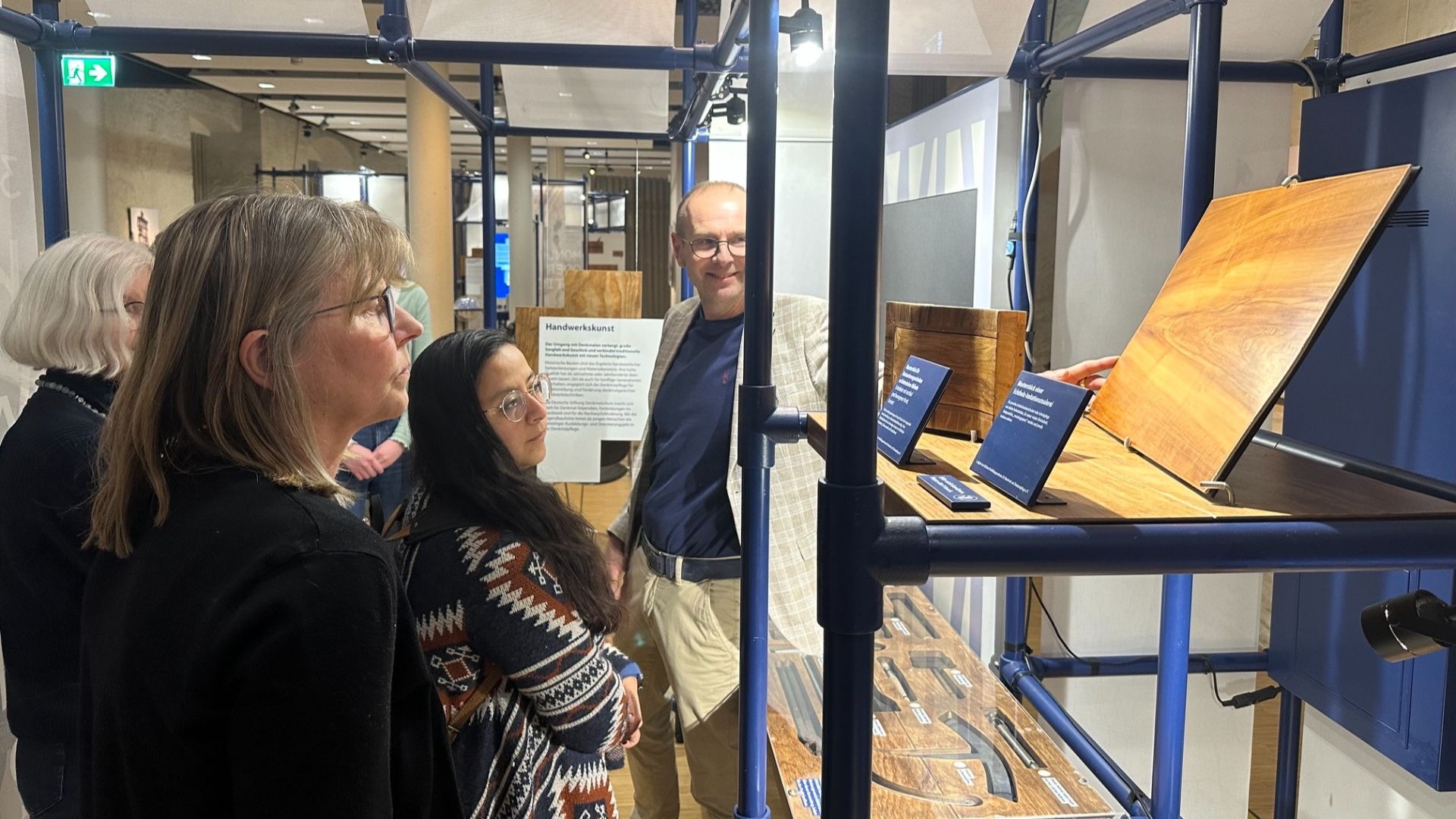 Ortskurator Frank Budde führt mehrere Personen durch eine Ausstellungshalle mit Exponaten