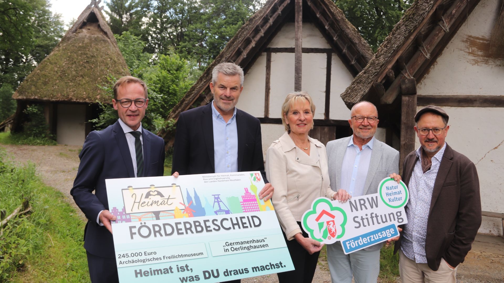 Fünf Personen präsentieren Förderscheck vom Ministerium und Förderzusage der NRW-Stiftung für das Germanenhaus