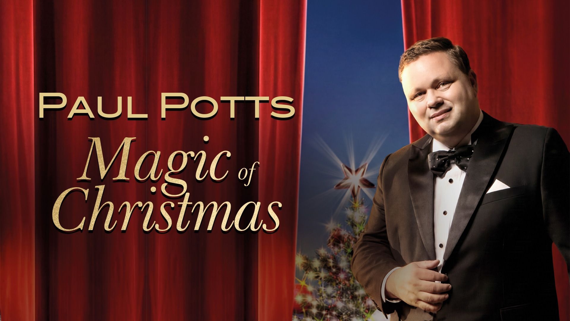 Paul Potts im schwarzen Smoking lächelt vor rotem Vorhang und Weihnachtsbaum mit Stern