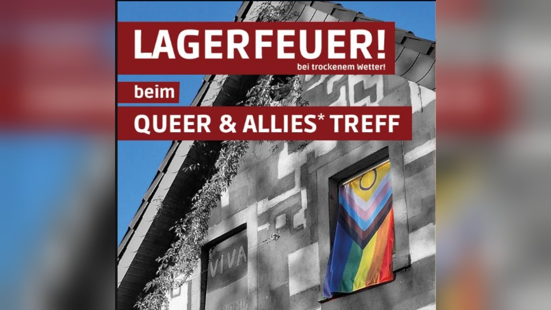 Gebäude mit Rankpflanzen, einer im Fenster hängenden Progress Pride Flagge und rotem Text "Lagerfeuer Queer & Allies*
