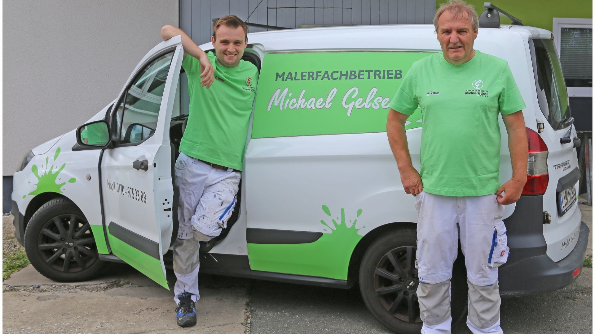 Zwei Männer in Maler-Arbeitskleidung stehen lächelnd vor einem weißen Firmenwagen mit dem Logo „Malerfachbetrieb