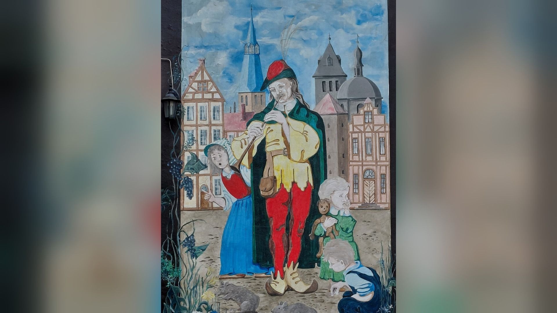Der Rattenfänger von Hameln spielt Flöte, umgeben von Kindern, Ratten und einer Frau, vor mittelalterlichen Häusern