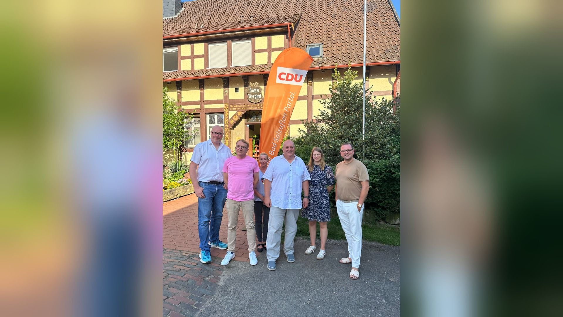 Fünf Männer und eine Frau stehen vor einem orangefarbenen CDU-Banner und Haus Berghof