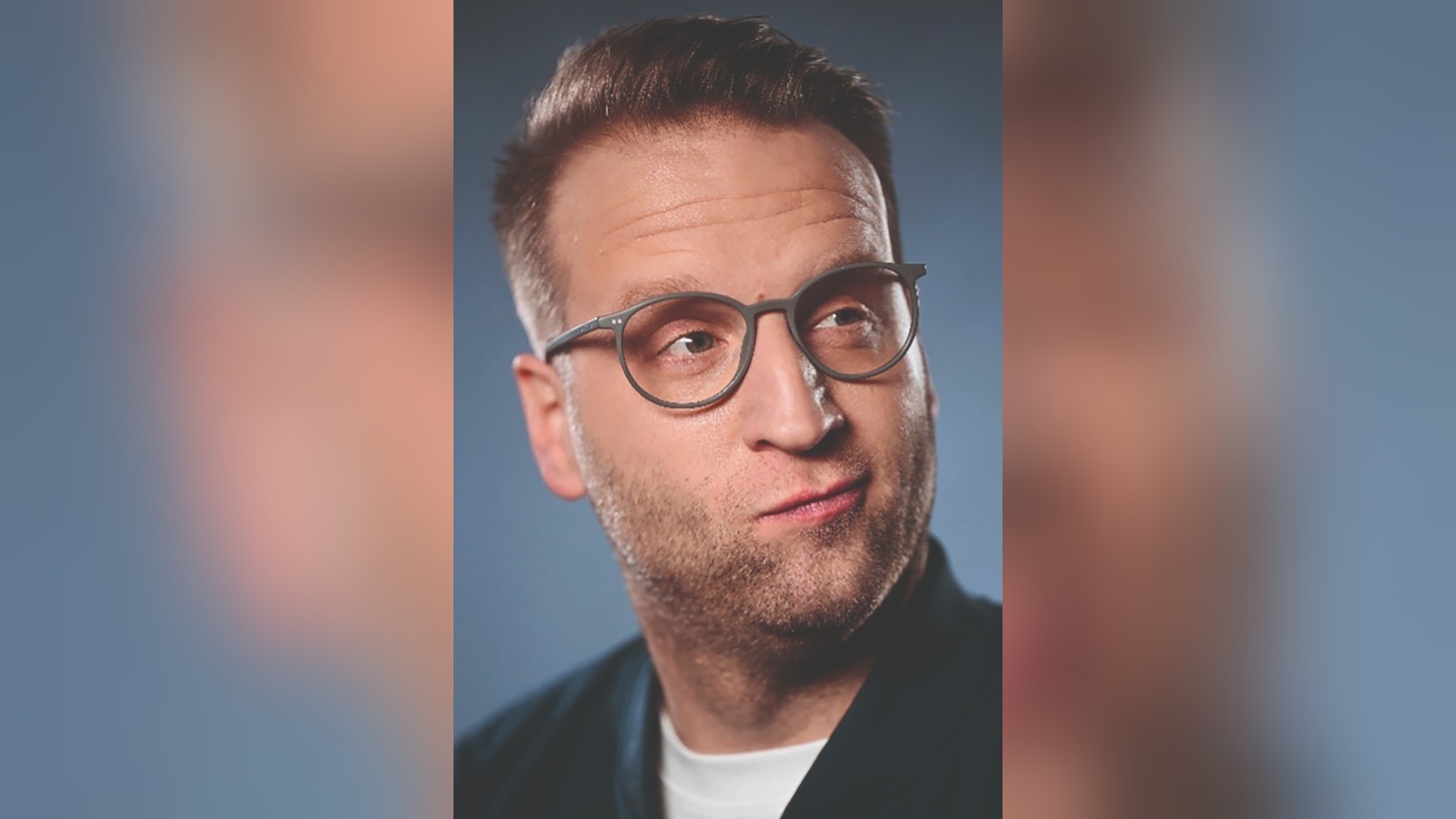 Benni Stark mit Brille und leicht schmunzelndem Gesicht blickt zur Seite