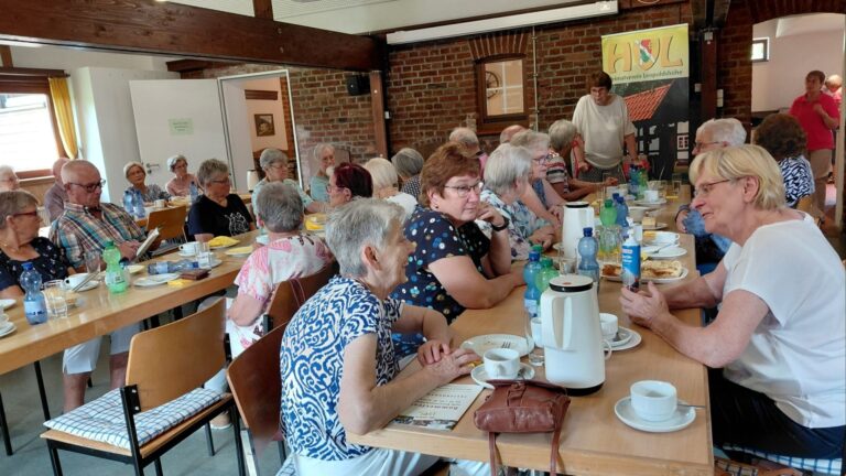 Senioren sitzen im Raum des Heimatvereins Leopoldshöhe an Tischen bei Kaffee und Kuchen zusammen und unterhalten sich
