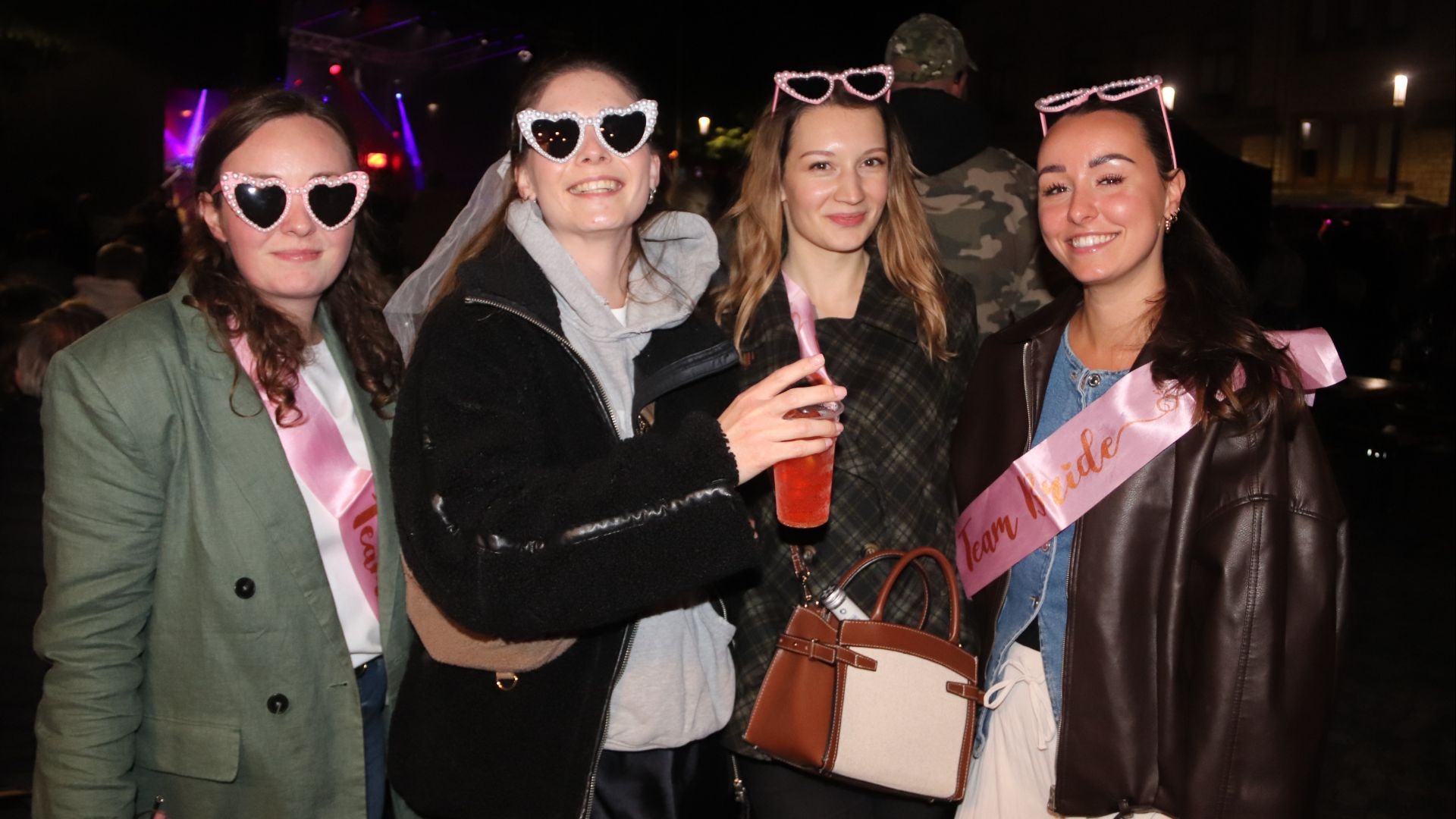 Vier junge Frauen lächeln, zwei tragen