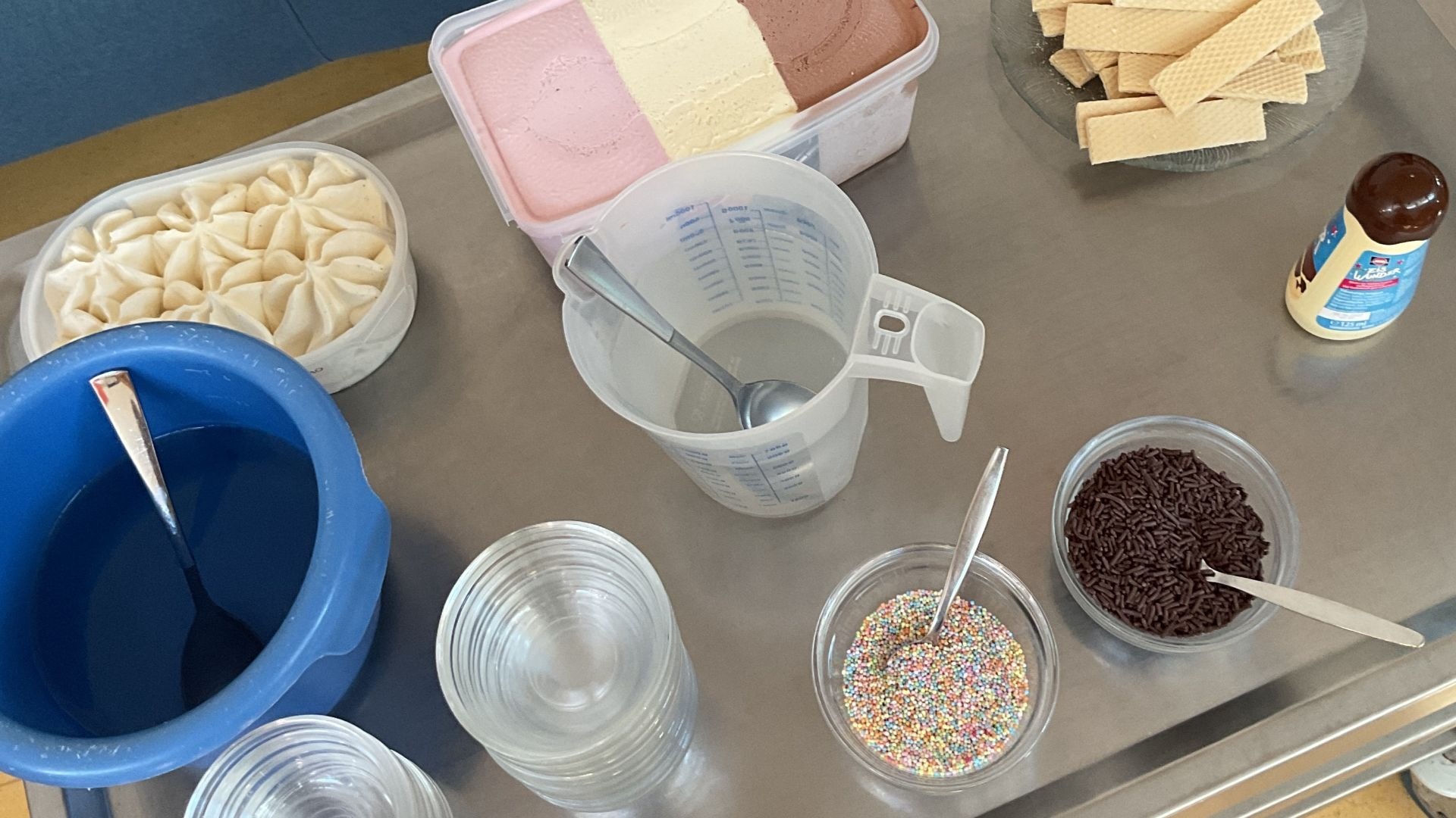 Servierwagen mit Behälter Neapolitaner Eis, Waffeln, Schoko- und bunten Streuseln, Schokosoße, Löffeln und Gläsern