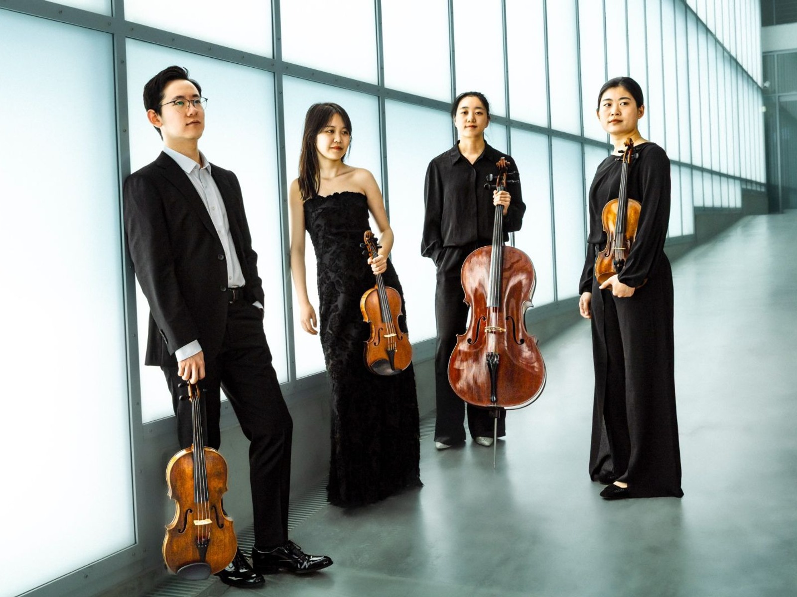 Das Seeberg Quartett posiert mit drei Violinen und einem Cello in einem hellen Gang