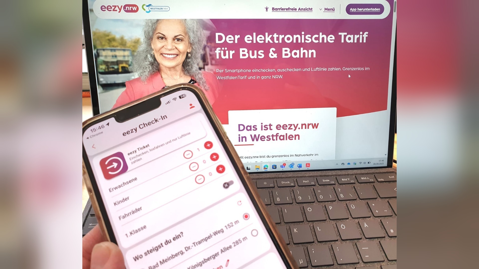 Ein Smartphone zeigt die eezy Ticket-App vor einem Laptop mit der eezy.nrw Website