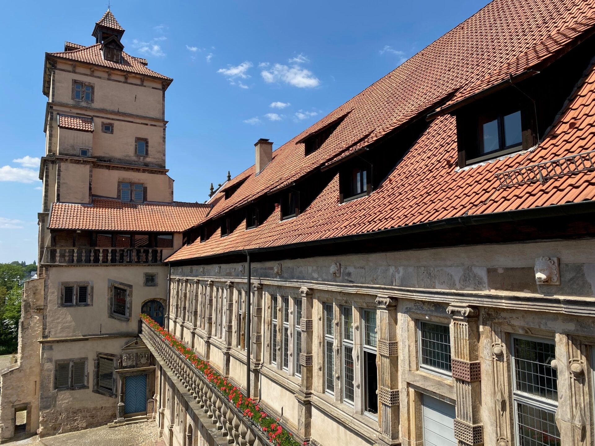 Weserrenaissance-Museum mit hohem Turm, roten Ziegeldächern, vielen Fenstern und Balustrade mit Blumen