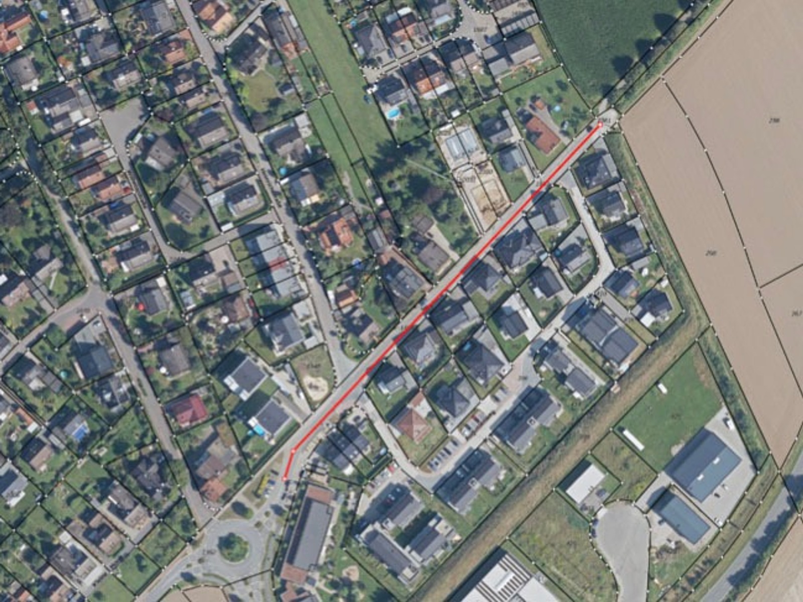 Luftbild der Schötmarschen Straße, rot markiert vom Gieselmann-Kreisel durch ein Wohngebiet bis zu Ackerfeldern