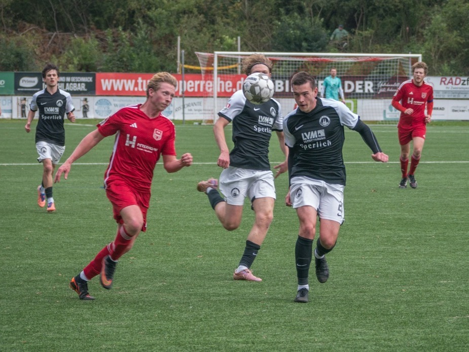 Fußballspieler von TuS Lipperreihe und TBV Lemgo kämpfen auf dem Rasen um den Ball, ein Spieler köpft ihn