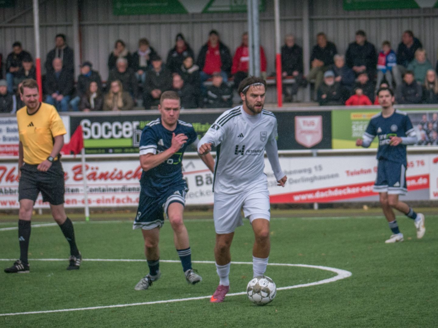 Fußballspieler von TuS Lipperreihe im weißen Trikot dribbelt den Ball, ein Gegner in blauem Trikot und der